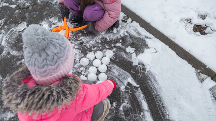 Active recreation with children in winter on cold days. Happy siblings having fun with snow