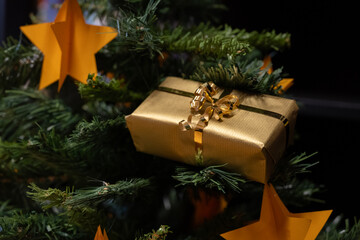 Goldenes Päckchen auf einem Weihnachtsbaum