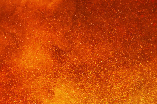 Abstract background with chaotic orange particle flow representing fiery world and universe creation. Bright big bang explosion design perfect for business, technology, presentations, advertising