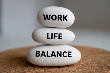 Work life balance concept with stacked white stones, wellness, stress management, harmony, mindfulness.