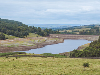 Views of Errwod Reservoir in Derbyshire, UK, showing extremely low water levels during a summer heatwave