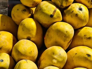 Fresh yellow mangoes piled high for sale at a market perfect for summer fruit recipes and desserts