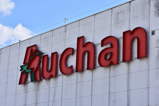 Auchan supermarket facade with emblem, signage, logo. WARSAW, POLAND - MAY 31, 2024