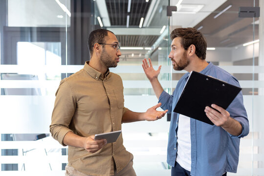 Office colleagues discussing a disagreement during a heated workplace conversation