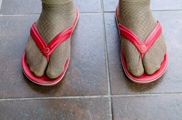 Funny fashion fail with socks and flip flops on tiles