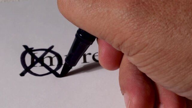 A close-up view of a hand holding a pen, carefully editing text on paper by striking out the prefix &ldquo;im&rdquo; from the word &ldquo;imprecise&rdquo; to highlight its positive form &ldquo;precise.&rdquo;