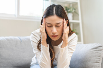 Dizzy asian young woman, girl headache or migraine pain suffering from vertigo while sitting on...