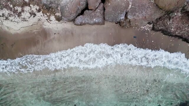 Drone detail of a cove at Puntas de Calnegre and Cabo Cope in Lorca, Murcia Region, Spain, with waves breaking on the shore.