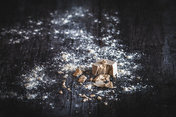 Fresh yeast crumbs and flour on dark background
