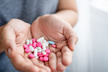 Close Up of Woman’s Hand Holding Many Different Pills  , Concept of Health Care, Treatment, Medication, and Daily Supplements, overdose 