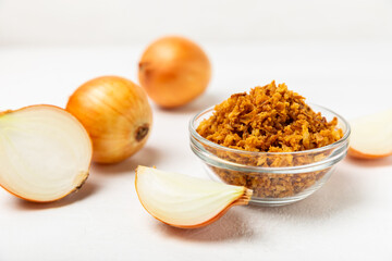 Crispy fried onions in a bowl on a wooden table. Roasted Onions. Seasoning for dishes. Spices....