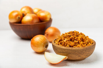 Crispy fried onions in a bowl on a wooden table. Roasted Onions. Seasoning for dishes. Spices....