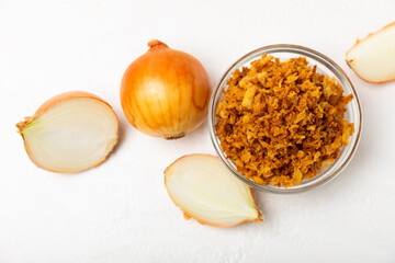Crispy fried onions in a bowl on a wooden table. Roasted Onions. Seasoning for dishes. Spices....