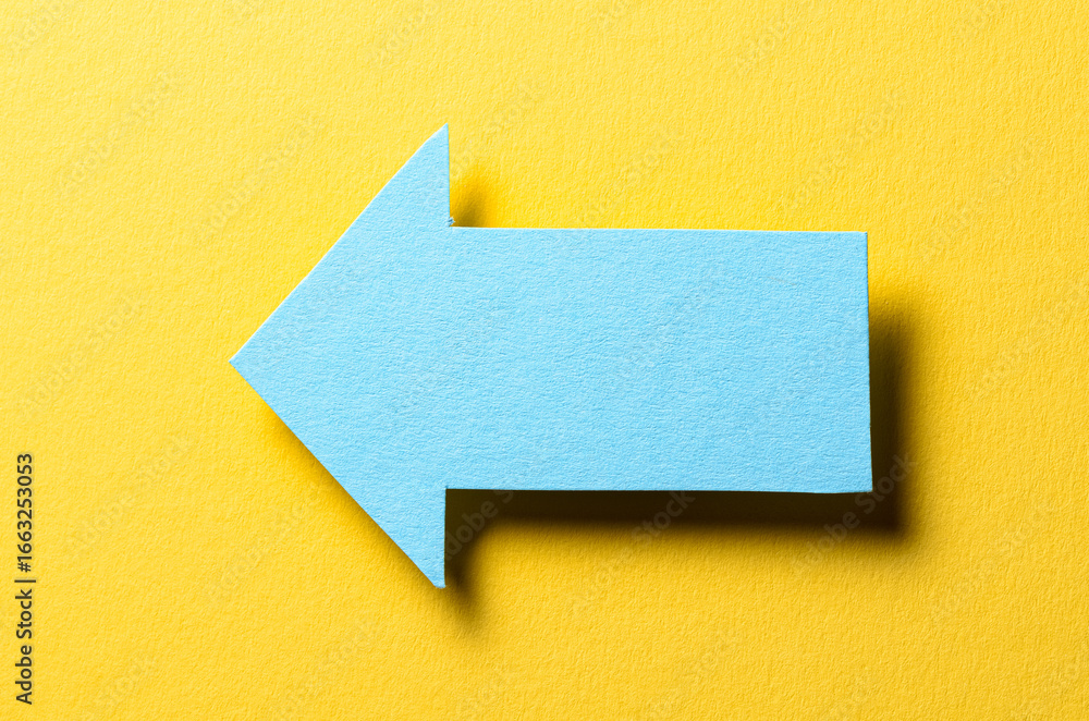 Poster blue cut out blank paper cardboard arrow direction sign with copy space for text on yellow backgroun