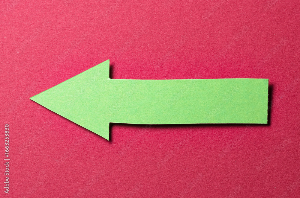Poster green cut out blank paper cardboard arrow direction sign with copy space for text on red background,