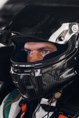 Racing Driver in Carbon Fiber Helmet Sitting Inside Race Car Cockpit During Track Day