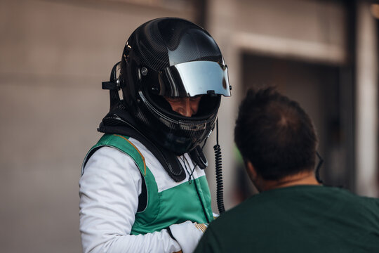 Racing Driver in Carbon Fiber Helmet Sitting Inside Race Car Cockpit During Track Day