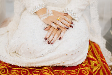 White wedding dress with hands and red henna on Muslim brides