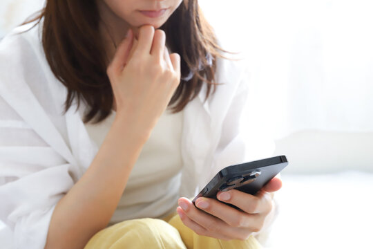 スマートフォンを見て落ち込む女性