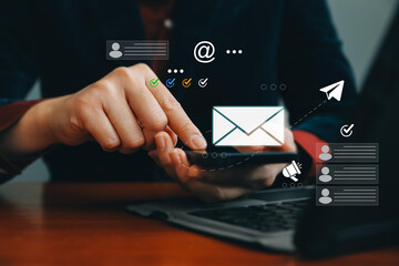 Businessman using email marketing tools on laptop and smartphone, sending newsletters and analyzing...