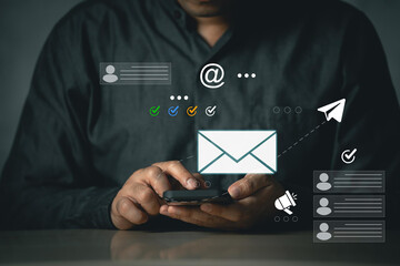Businessman using email marketing tools on laptop and smartphone, sending newsletters and analyzing...
