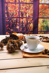 Tazza di caffè con ambientazione autunnale su sfondo con paesaggio autunnale