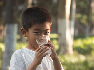 Chinese children drinking water outdoors in summer
