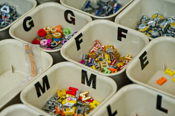 Colorful alphabet bead boxes neatly organized for crafts and jewelry making with letter g f m