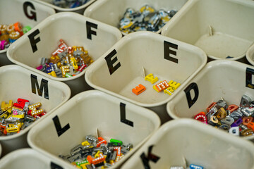 Colorful alphabet bead boxes neatly organized for crafts and jewelry making with letter f e L
