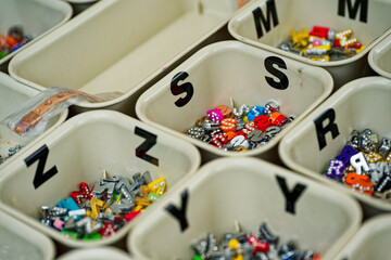 Colorful alphabet bead boxes neatly organized for crafts and jewelry making with letter s z y