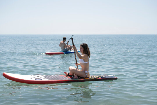 Tourists enjoying stand up paddle boarding on calm sea
