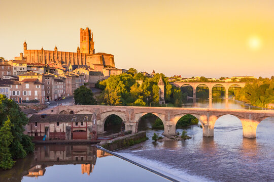 Colorful sky at sunrise over the historic bridges and cathedral in Albi, France