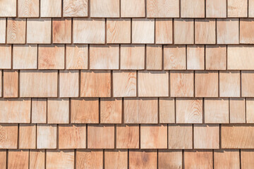 Wooden shingle roof background of new red brown cedar shake wood tile siding row panel pattern made of larch conifer tree in building construction for house design industry