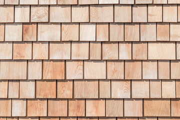 Wooden shingle roof background of new red brown cedar shake wood tile siding row panel pattern made of larch conifer tree in building construction for house design industry