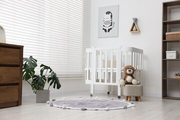 Baby's room with comfortable crib and teddy bear. Interior design
