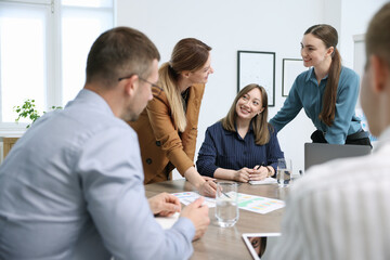 Business coach working with group of people in office