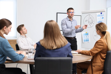 Obraz premium Business coach giving presentation to group of people in office