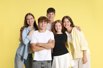 Obraz premium Portrait of happy teenage friends on yellow background