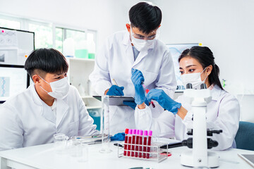 Diverse team of scientists, with a strong female presence, collaborating on blood testing in a...