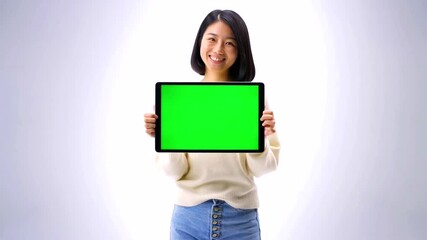 A smiling woman holding a tablet with a green screen in front of a white background - Powered by Adobe