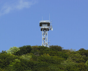 A antenna tower and a parabolic antenna attached to it at the top of the mountain.
The view from the mountain surrounding the inland sea of Japan.