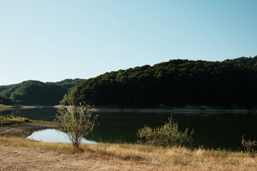 Scenic summer view of Garasko Lake Jezero Garasi in Serbia with calm water, forested hills, and clear sky on a sunny day