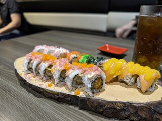 Colorful sushi rolls with salmon and toppings on a wooden board for japanese cuisine lovers