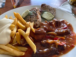 Delicious plate featuring steak with herb butter fries and flavorful sauce close up