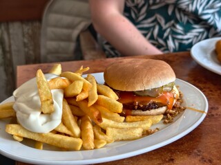 Burger and fries with mayonnaise on a white plate ready to be enjoyed