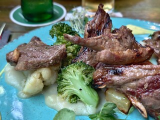 Grilled lamb chops with broccoli and cauliflower on a vibrant blue plate