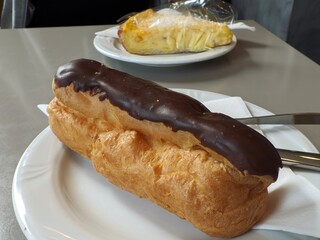 Chocolate éclair and custard pie on plates for a sweet dessert indulgence