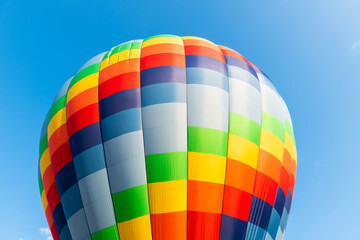 Colorful hot air balloon against the blue sky at sunny day.