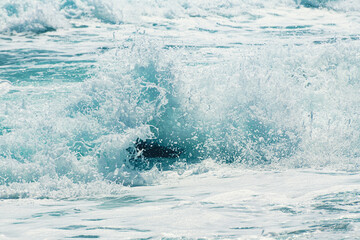 Waves on the beach in windy day. Sea foam splash close up. Santorini island, Greece.