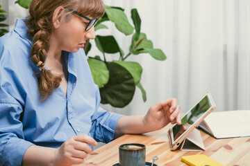 Elderly woman professor, teacher, tutor or psychologist reading scientific article on tablet in...